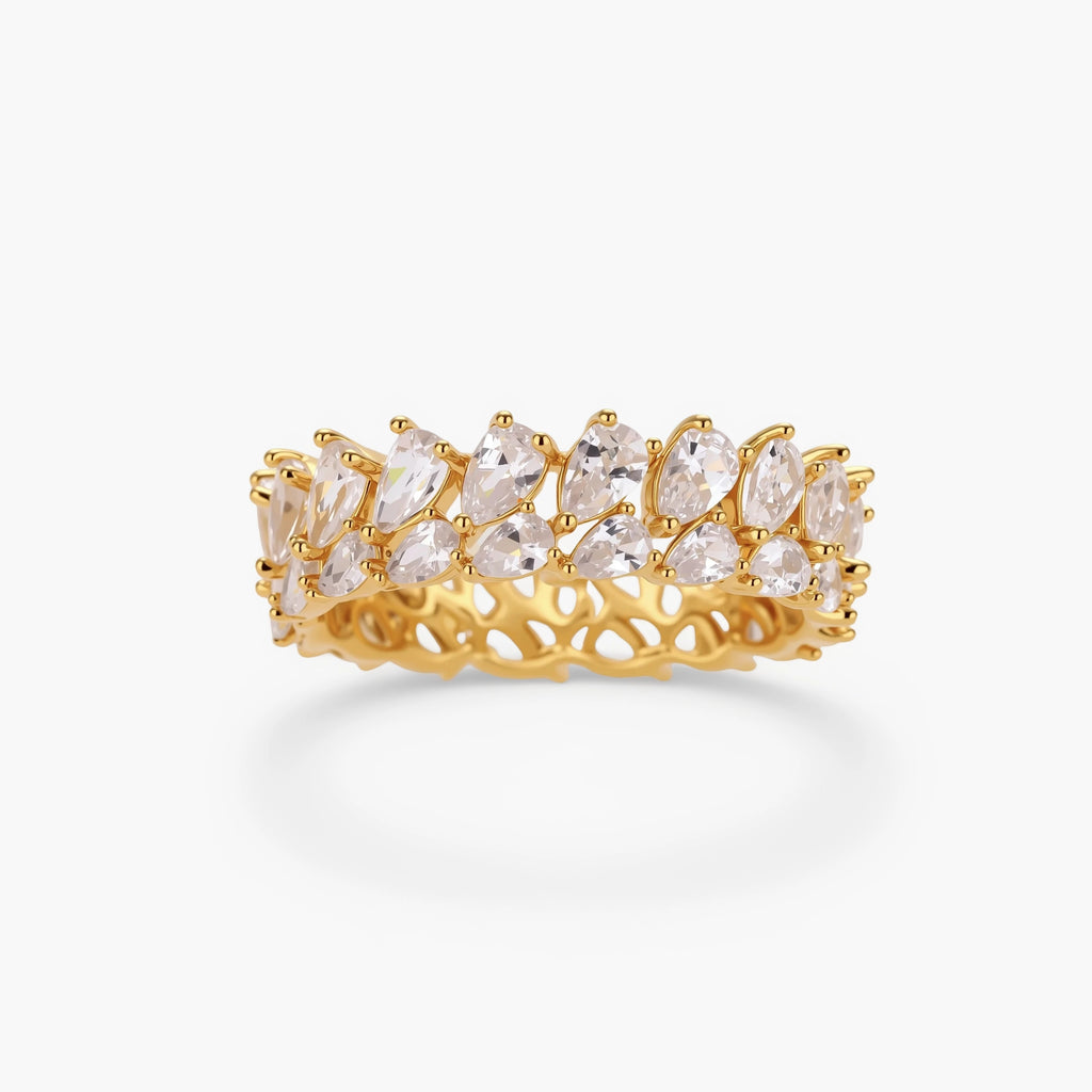 Adjustable gold-plated ring with double-row pear-shaped cubic zirconia stones in geometric pattern on cream background.