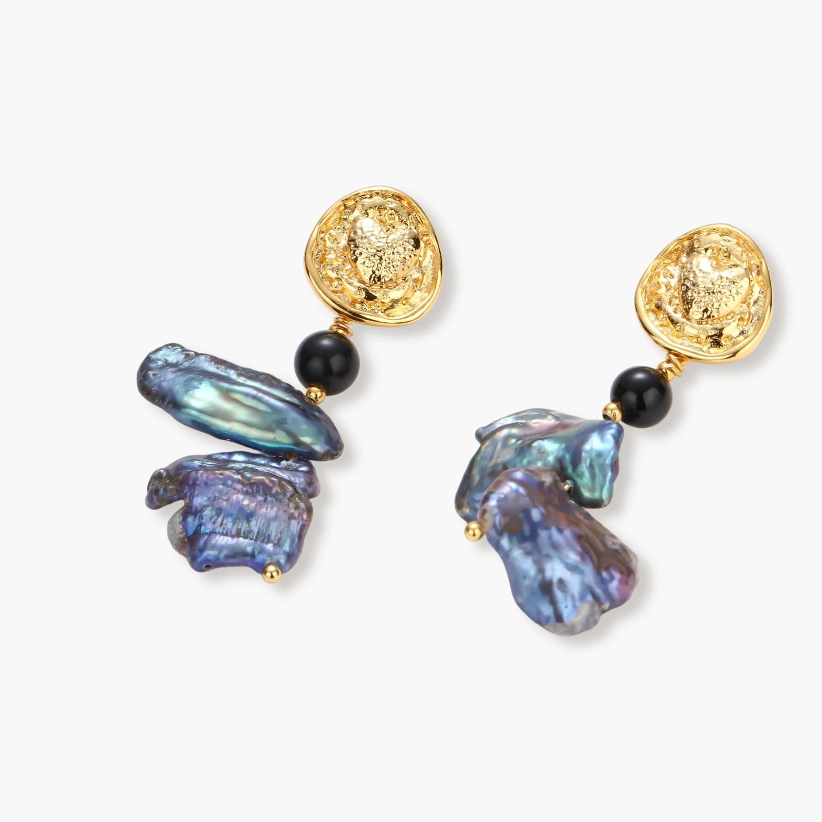 Ornate gold-plated drop earrings with black beads and iridescent blue-purple baroque pearls against white background.
