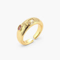Gold-plated adjustable ring with textured band featuring champagne and purple gemstones on white background.