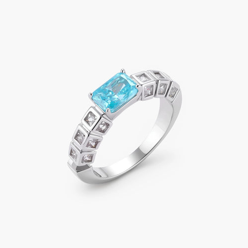Geometric silver-plated ring with rectangular aqua cubic zirconia center and square crystal details on adjustable band.