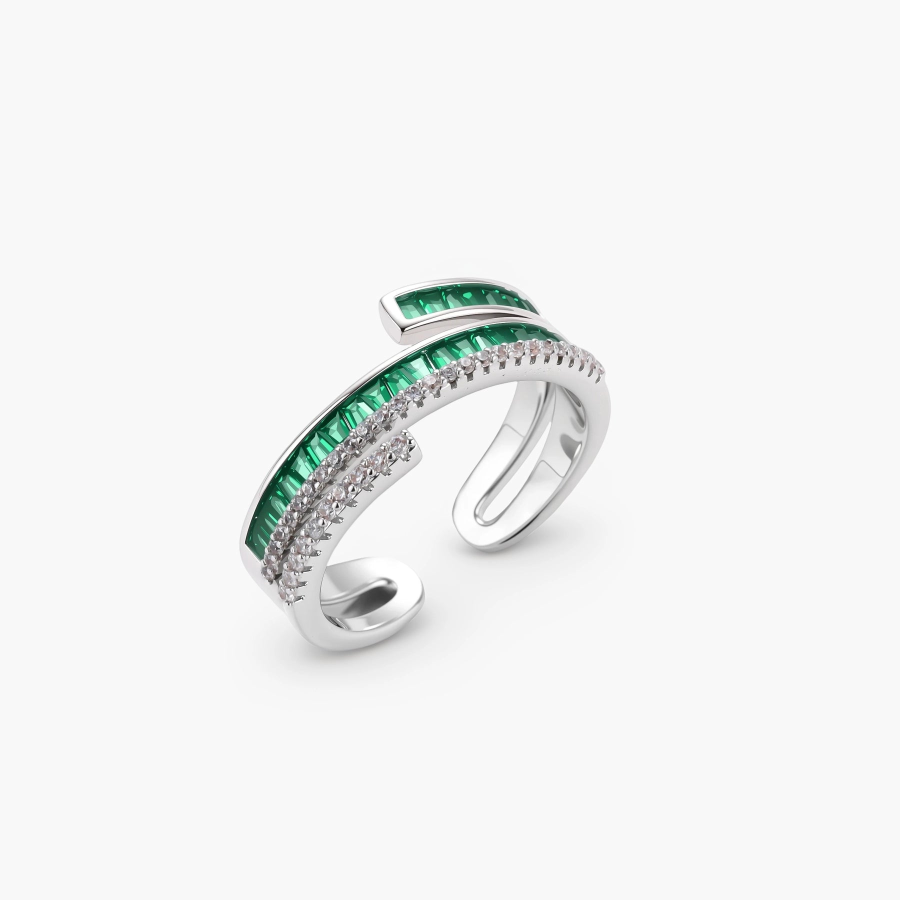 Modern adjustable ring with green baguette stones and clear crystals in parallel bands on white background.