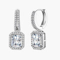 Sterling silver huggie hoops with emerald-cut moissanite drops featuring pavé-set crystals on white background.