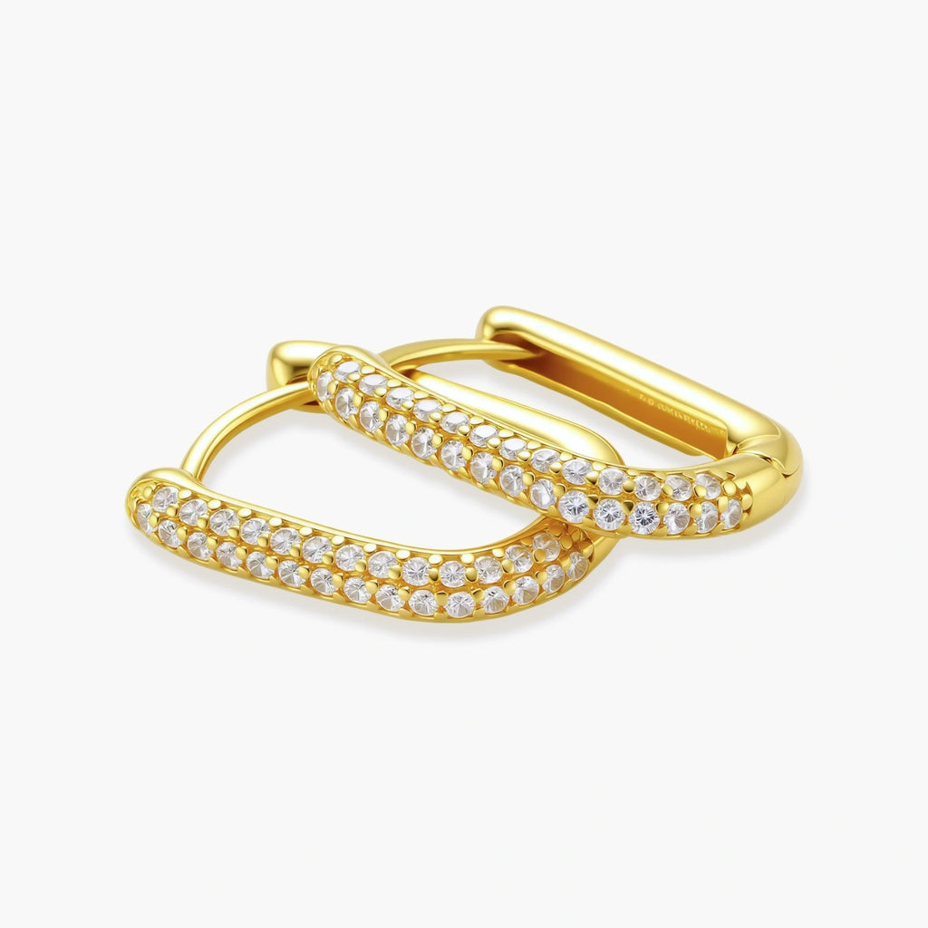 Close-up of gold-plated sterling silver huggie earrings with pave-set crystals creating a continuous sparkle around the hoop
