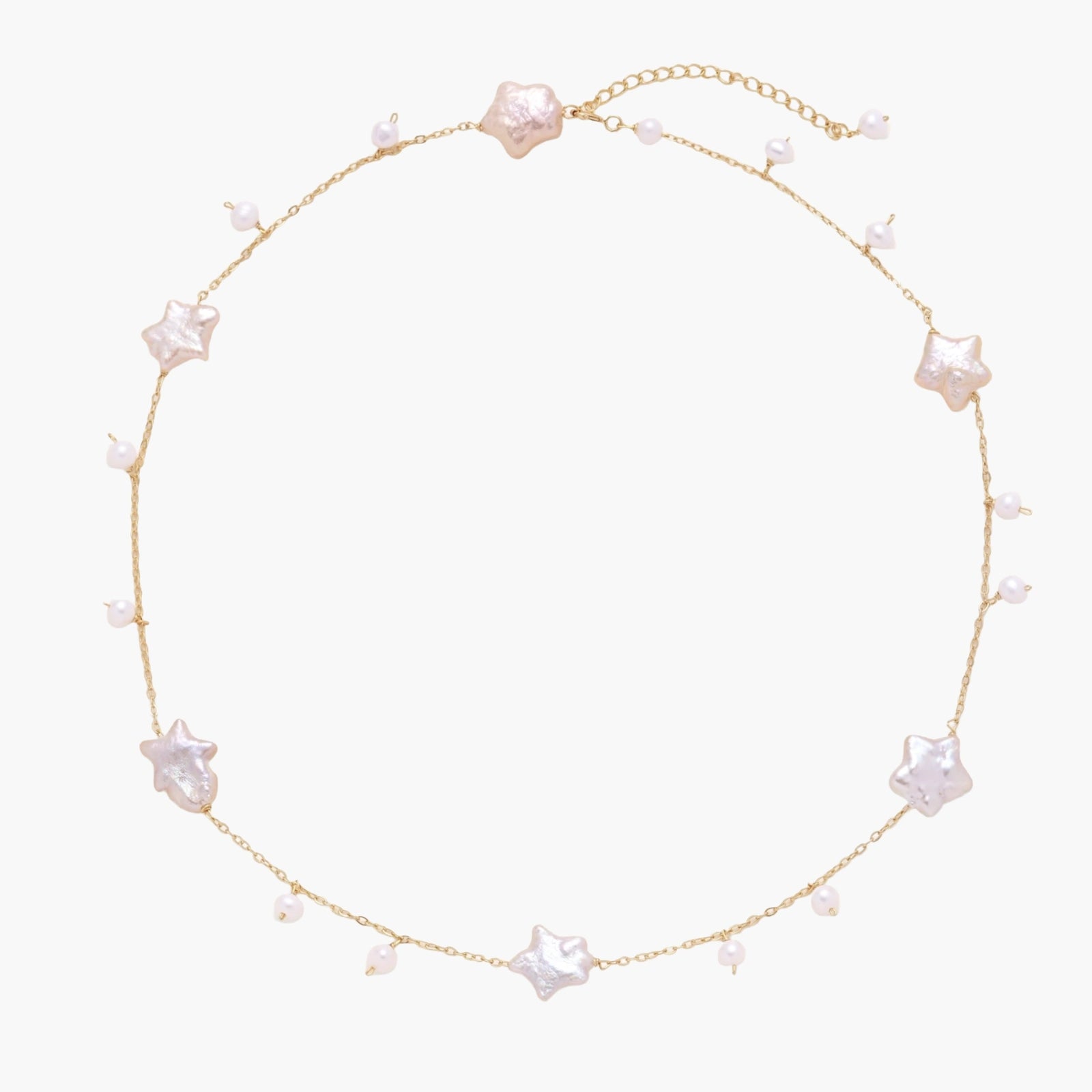 Gold vermeil chain with iridescent star-shaped baroque pearls and small round freshwater pearl drops on cream background.