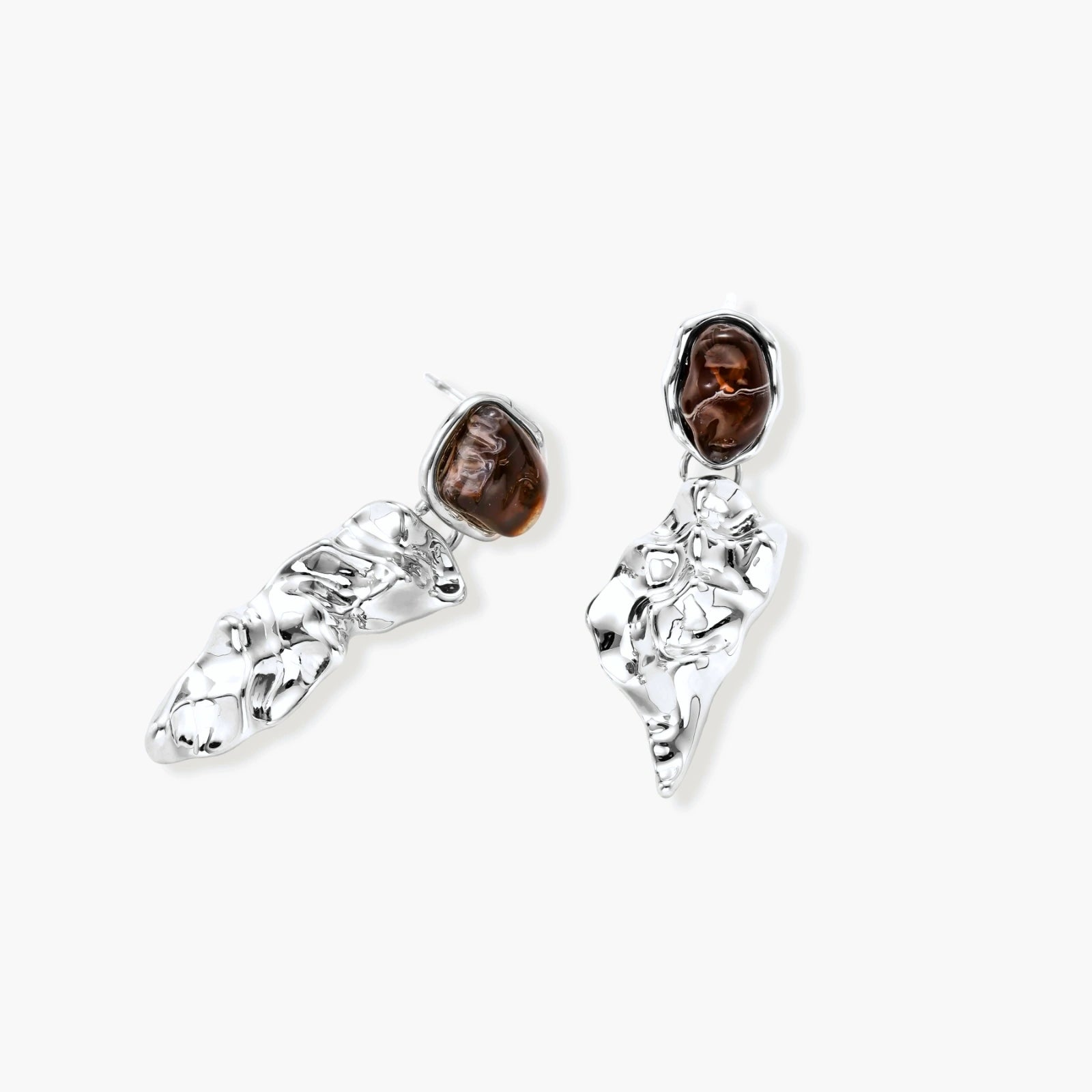 Abstract sculptural silver earrings with brown resin stones featuring organic fluid metalwork design on white background.