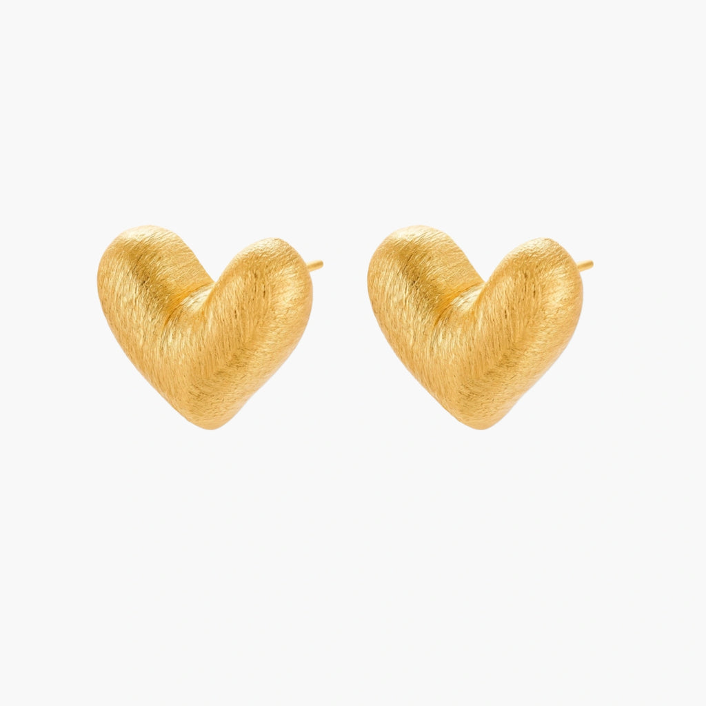 Pair of small heart-shaped stud earrings with brushed metallic finish, showing both silver and gold variants on neutral background.