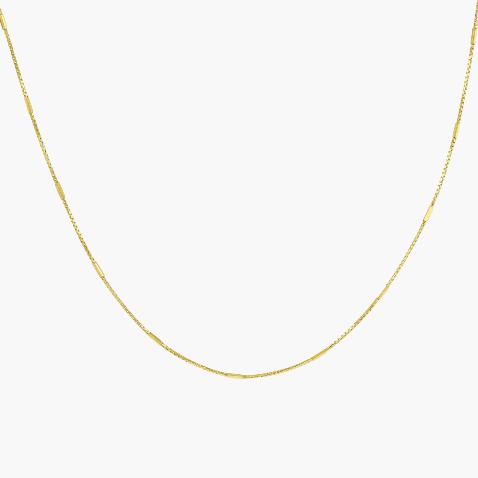 Delicate gold-plated sterling silver chain necklace with geometric segments displayed against cream background