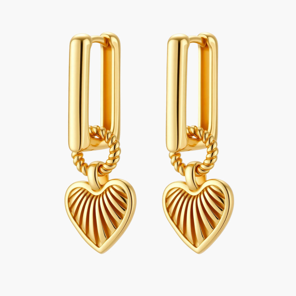 Gold-plated huggie earrings with textured heart charms featuring radiating sunburst patterns on white background.