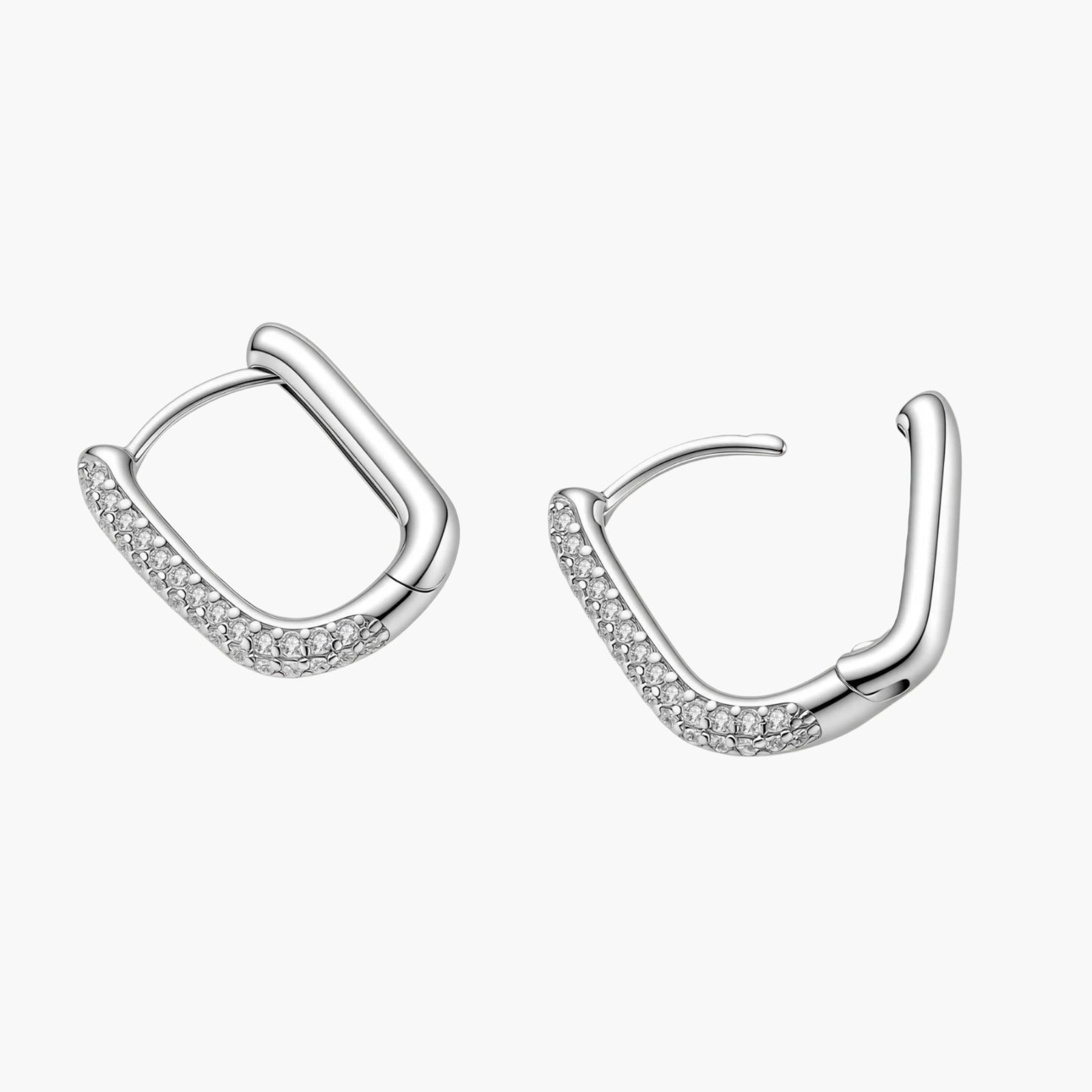 Close-up of platinum-plated sterling silver huggie hoops with pavé crystal setting on white background.