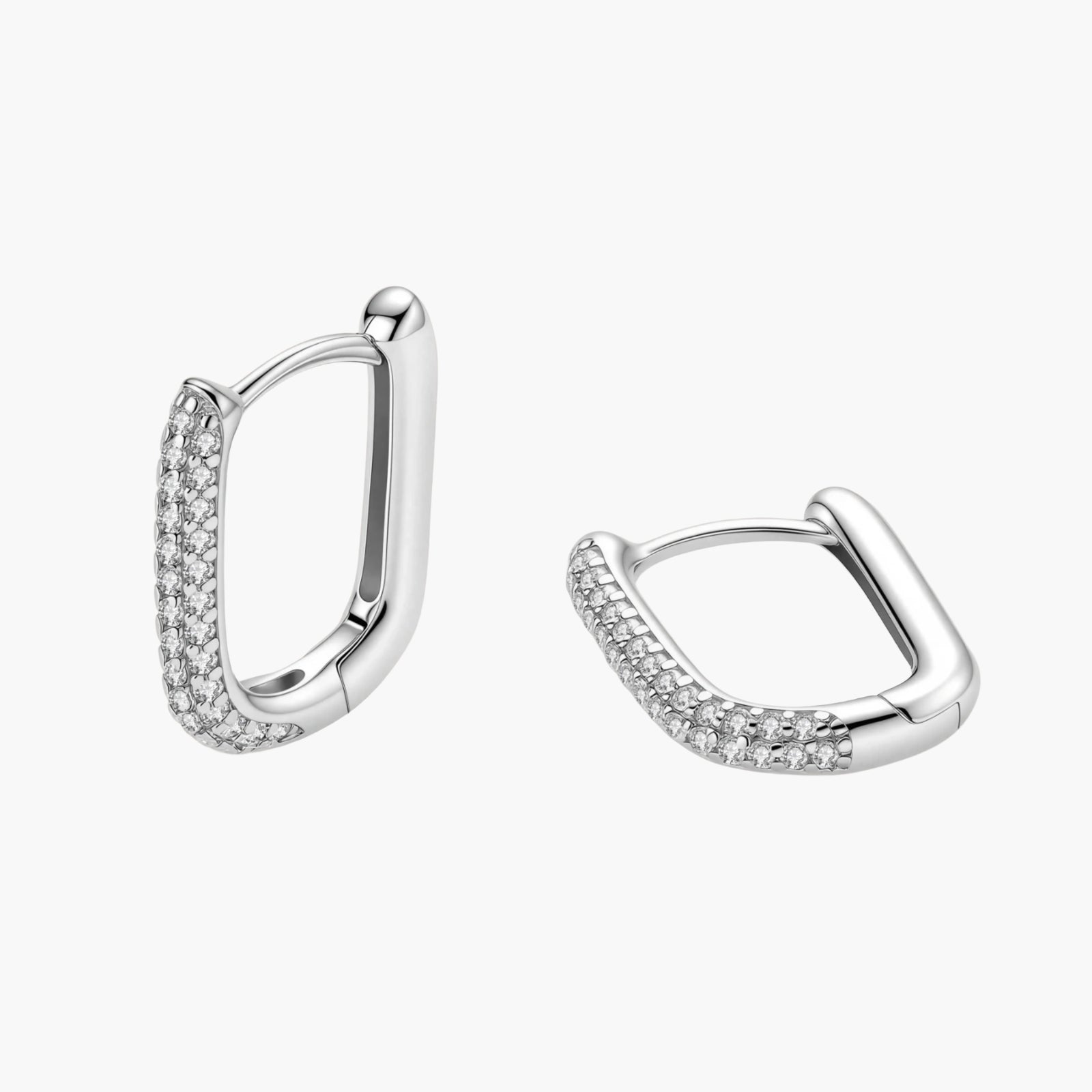 Close-up of platinum-plated sterling silver huggie hoops with pavé crystal setting on white background.