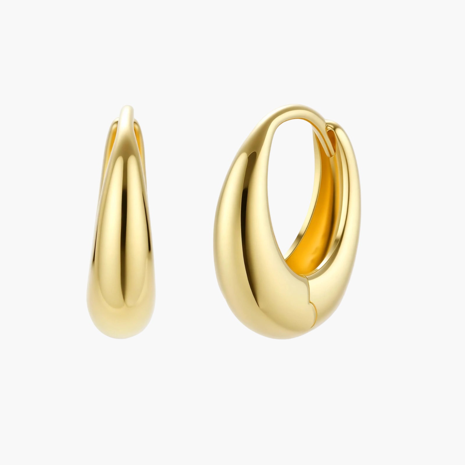Chunky gold-plated sterling silver huggie hoop earrings with hinged closure mechanism on cream background.