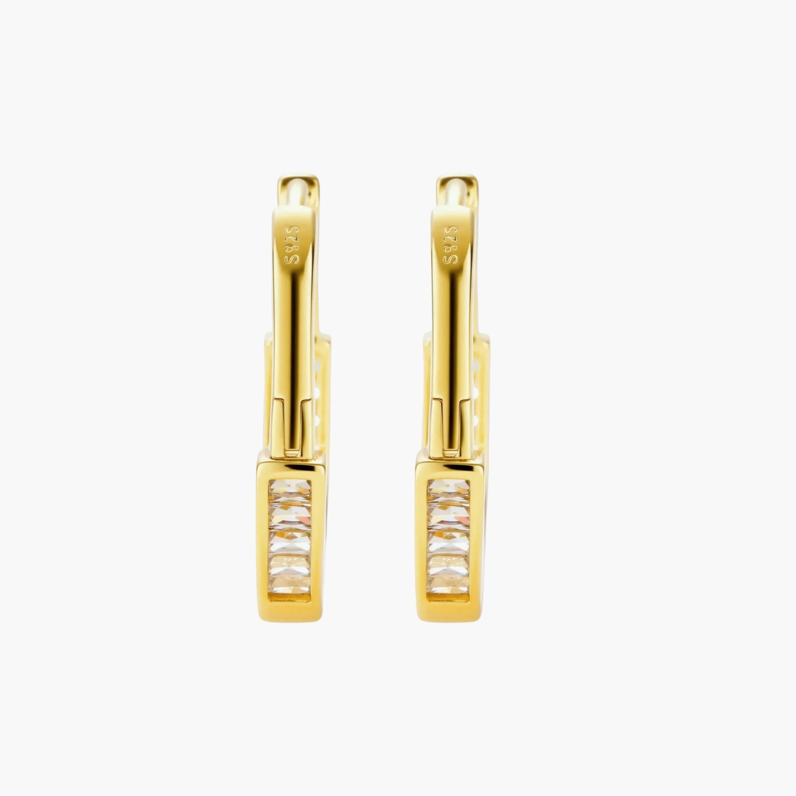 Close-up of gold-plated sterling silver huggie hoop earrings featuring rectangular cubic zirconia stones on neutral background.
