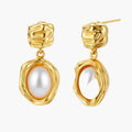Gold-plated textured stud earrings with white freshwater pearl drops against cream background, showing organic rippled design
