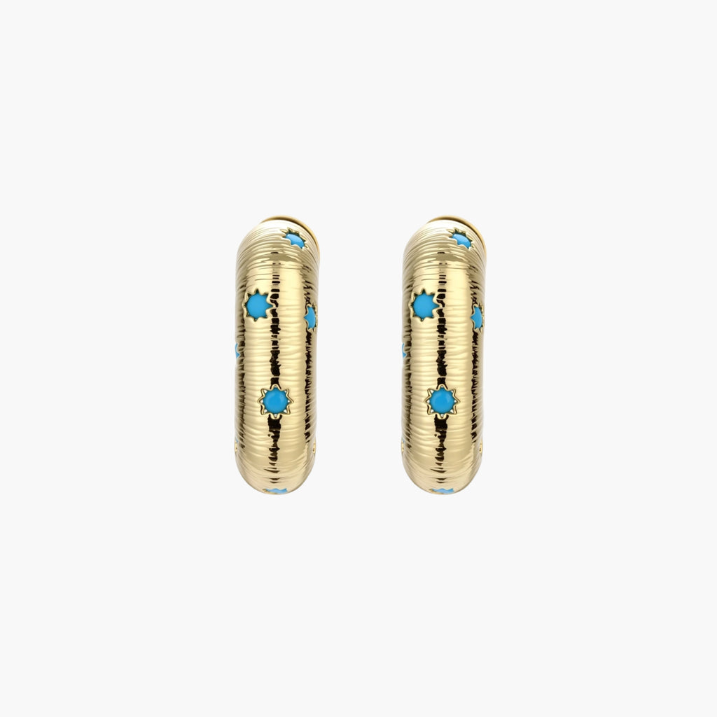 Gold-plated huggie hoop earrings with blue star inlays and textured surface, shown against white background.