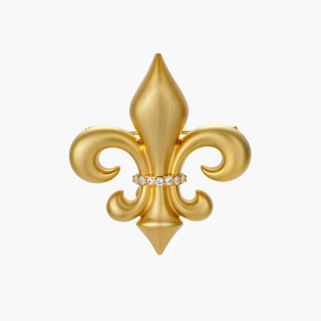 Ornate gold-plated fleur-de-lis brooch with crystal band detail on white background, showing brushed metal finish.
