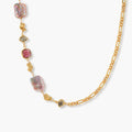 18k gold-plated chain necklace with iridescent baroque pearls and burgundy gemstones on white background.
