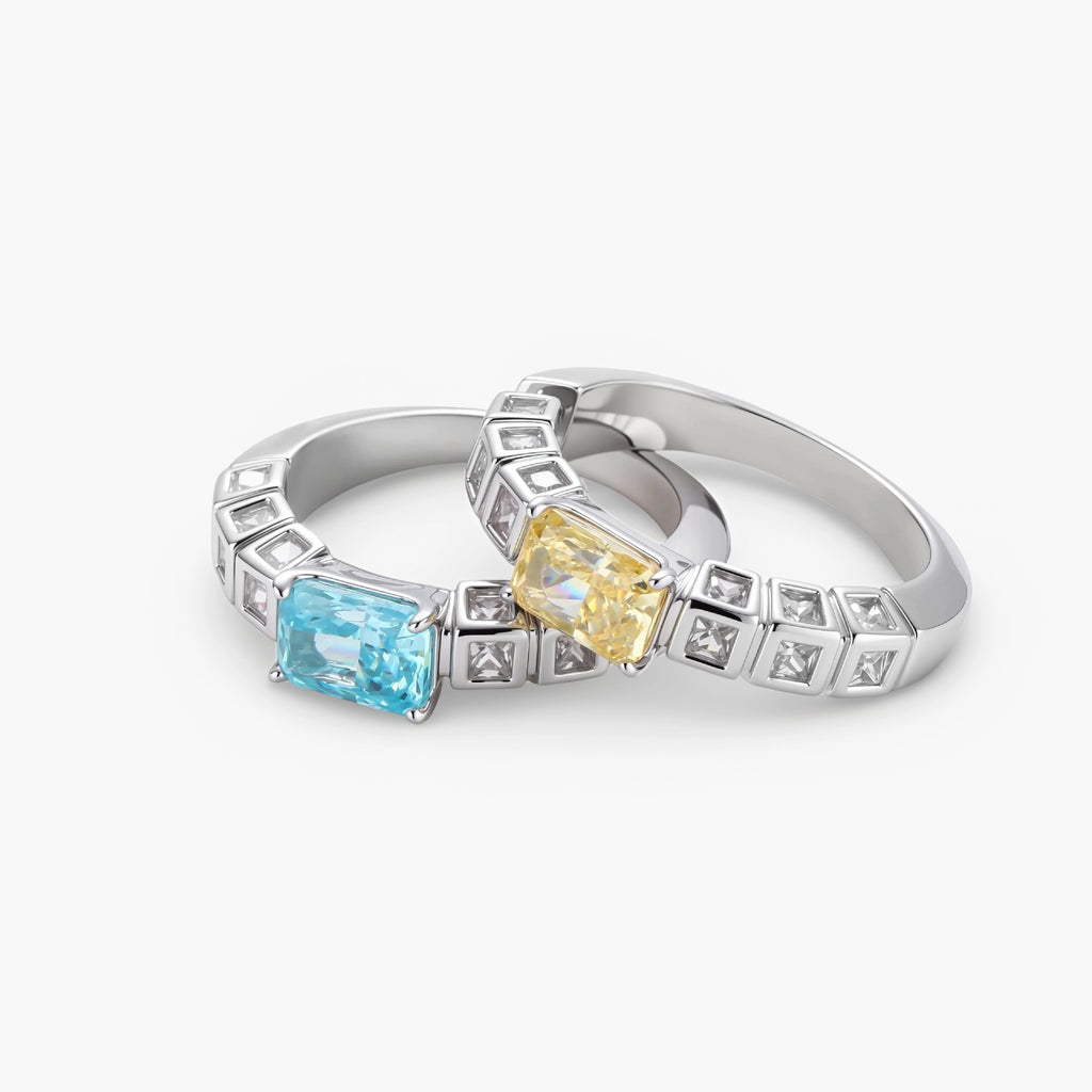 Adjustable ring with emerald-cut yellow zirconia center and clear accent stones in geometric platinum-plated setting