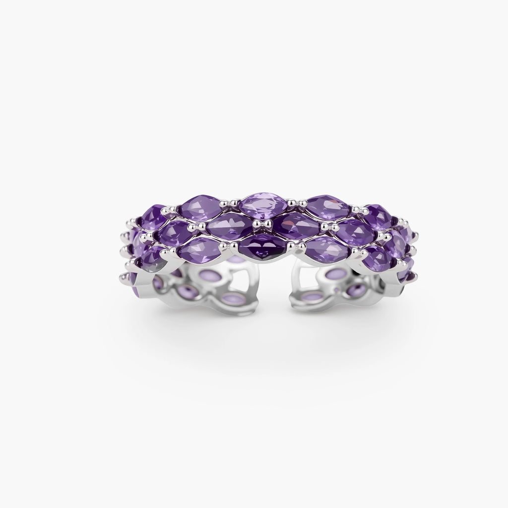 Close-up of adjustable ring with oval purple zirconia stones in white gold-plated copper setting on neutral background.