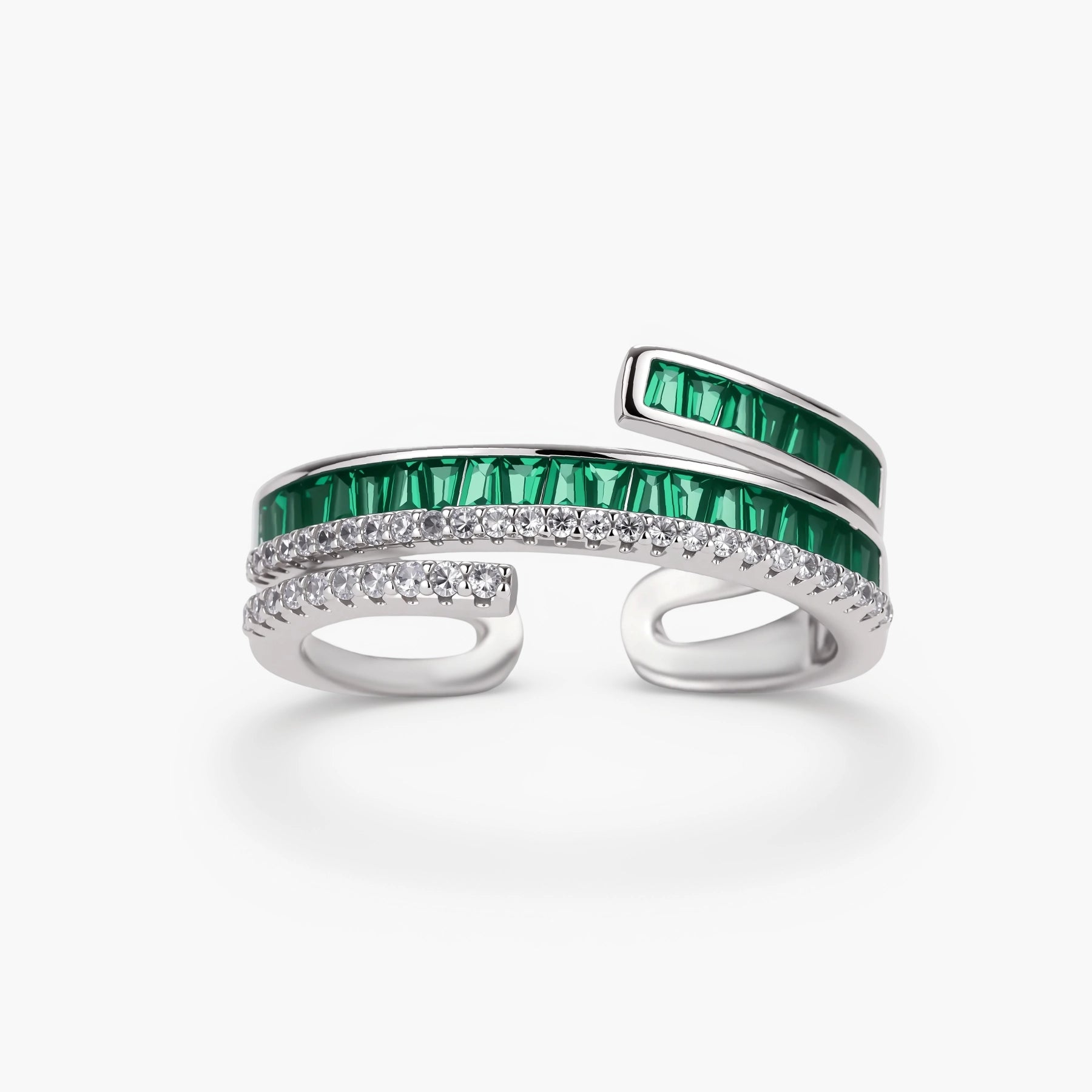 Modern adjustable ring with green baguette stones and clear crystals in parallel bands on white background.