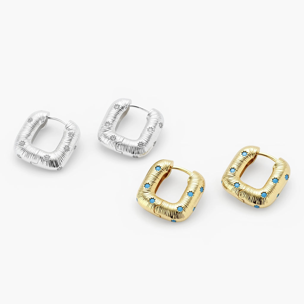 Gold-plated huggie hoop earrings with blue star inlays and textured surface, shown against white background.