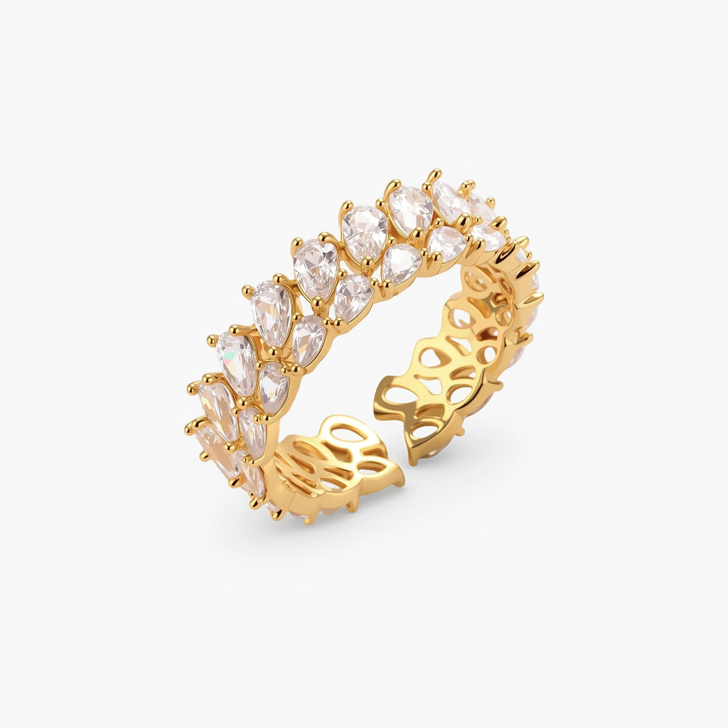 Adjustable gold-plated ring with double-row pear-shaped cubic zirconia stones in geometric pattern on cream background.