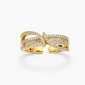 Close-up of gold-plated adjustable ring with crossing bands and sparkling zirconia stones on white background.