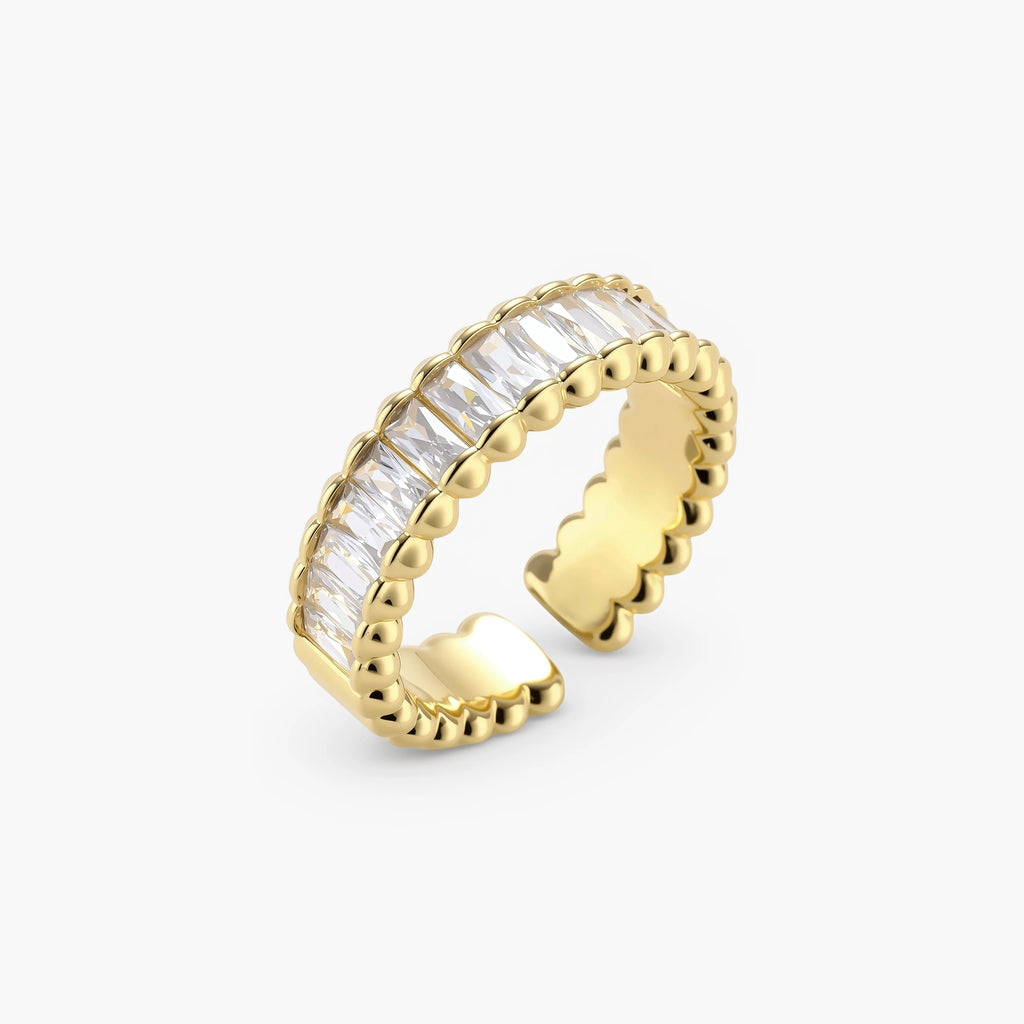 Adjustable gold-plated ring with rectangular cubic zirconia stones in eternity band style on neutral background.