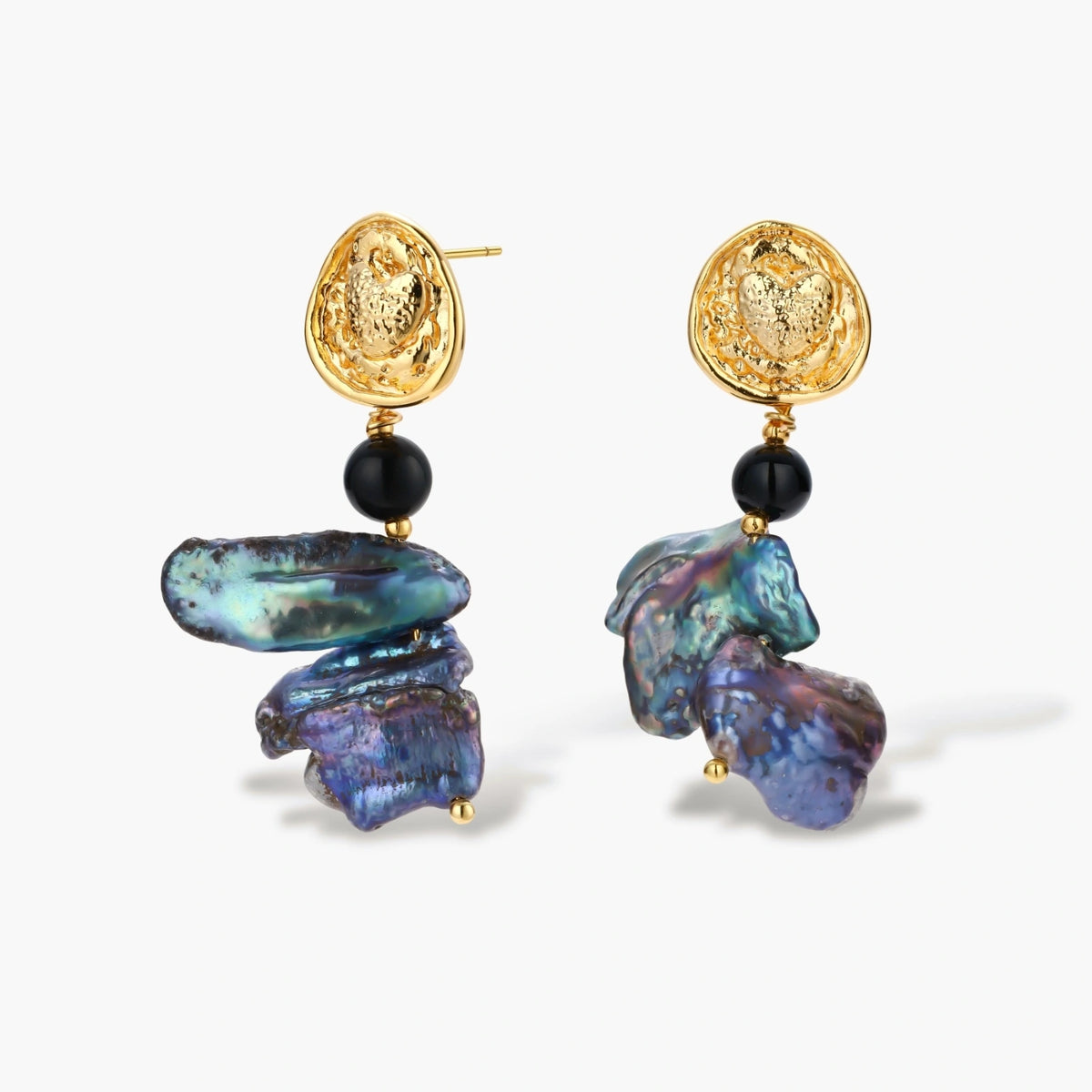 Ornate gold-plated drop earrings with black beads and iridescent blue-purple baroque pearls against white background.