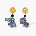 Ornate gold-plated drop earrings with black beads and iridescent blue-purple baroque pearls against white background.