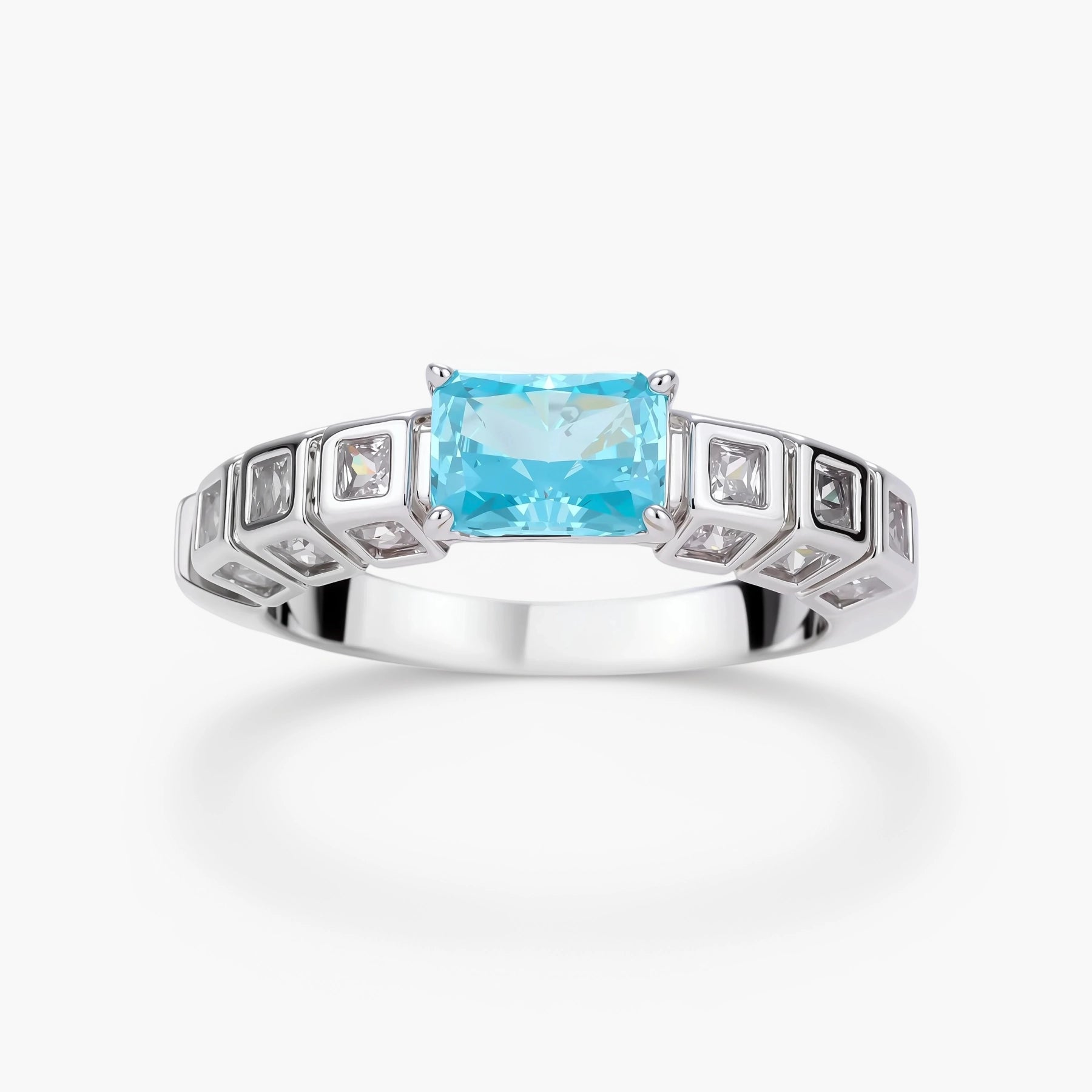 Geometric silver-plated ring with rectangular aqua cubic zirconia center and square crystal details on adjustable band.