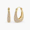 Gold-plated hoop earrings fully covered in sparkling zircon crystals with hinged closure on neutral background