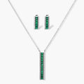 White gold plated jewelry set with emerald green rectangular stones and clear crystals in geometric rows on white background.