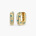 Gold-plated huggie hoop earrings with blue star inlays and textured surface, shown against white background.