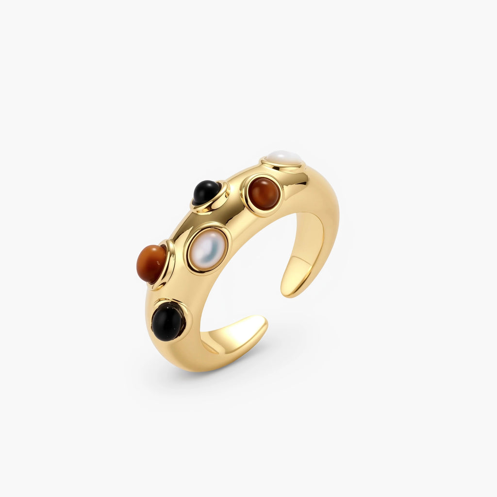 Gold-plated adjustable ring with white, amber, and black stones in organic bubble design on neutral background.