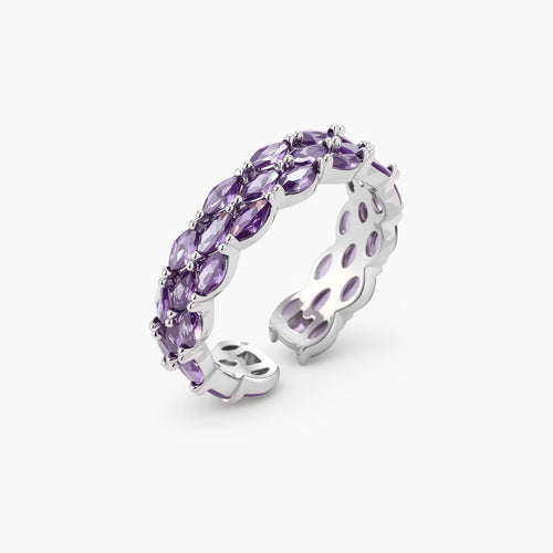 Close-up of adjustable ring with oval purple zirconia stones in white gold-plated copper setting on neutral background.