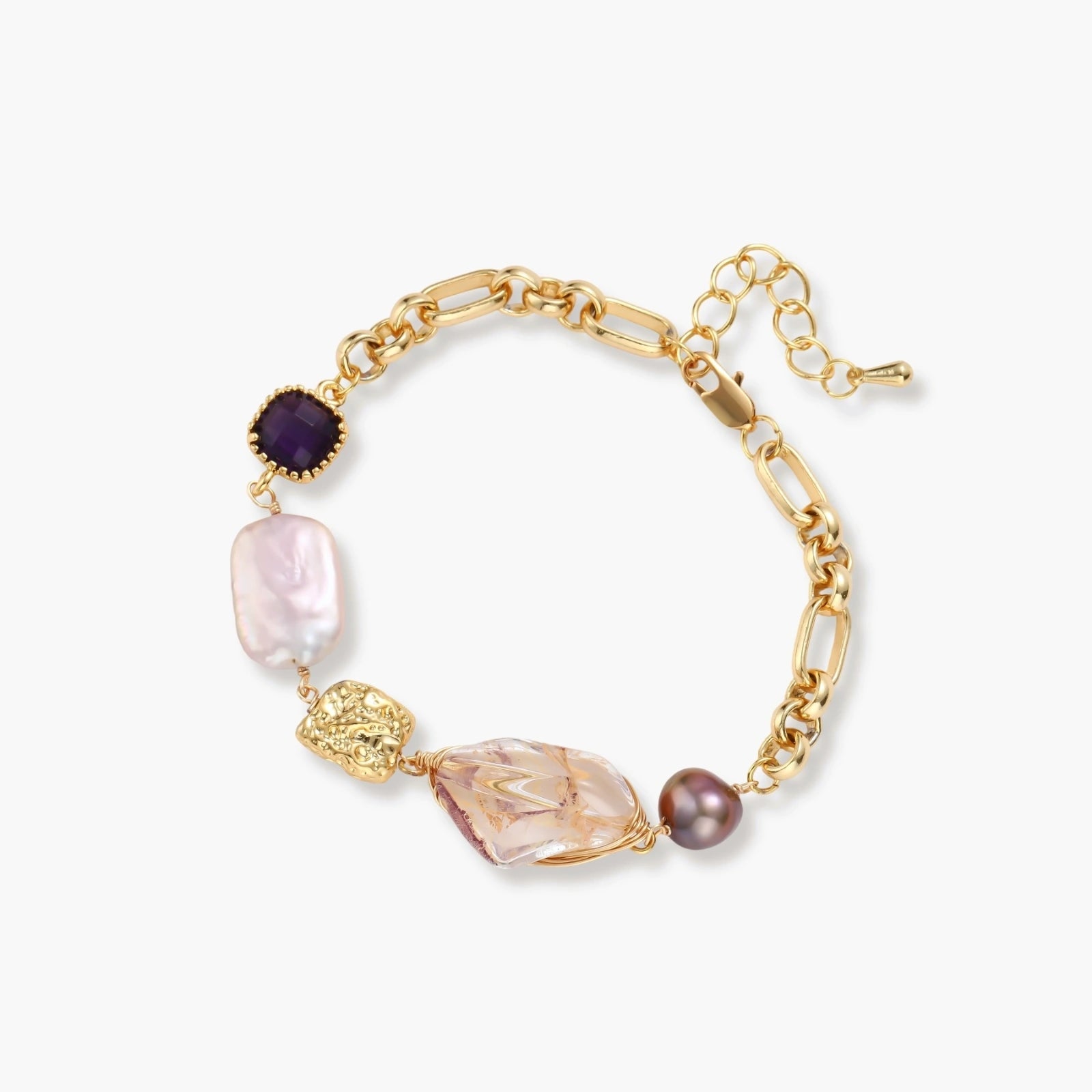 Gold-plated chain bracelet with mixed gemstones including purple stone, baroque pearl, and clear crystal on neutral background.