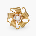 18K gold-plated bow brooch with dimensional ribbon design, pearl center, and sparkling zircon stones on white background.